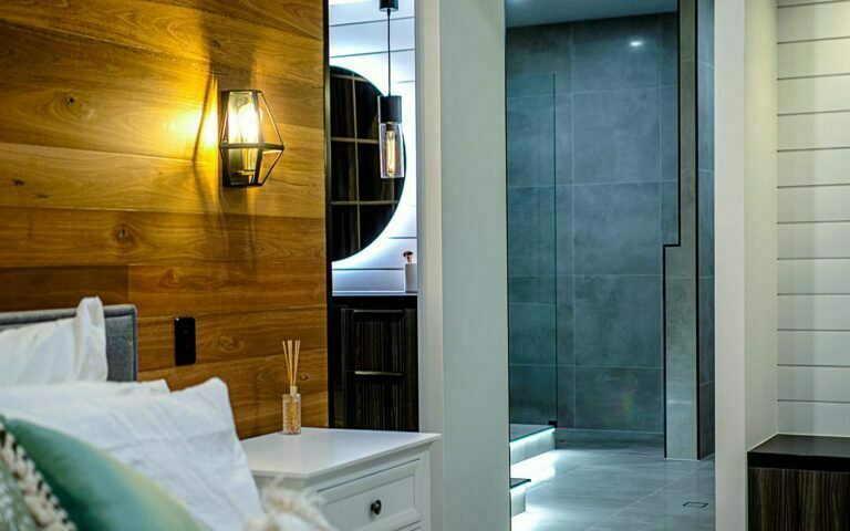 Perspective view from the master bedroom through the ensuite into the main bathroom. Feature natural timber wall, large stone tiles.